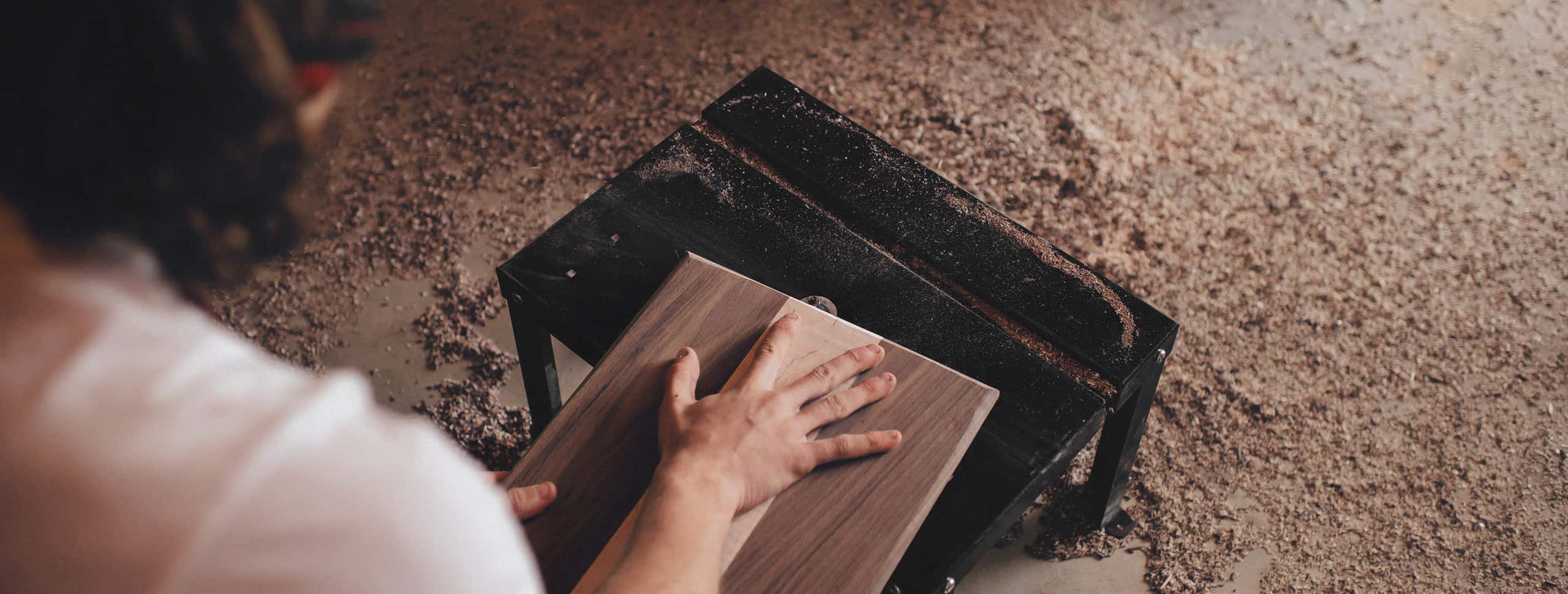 Hands sanding a piece of wood