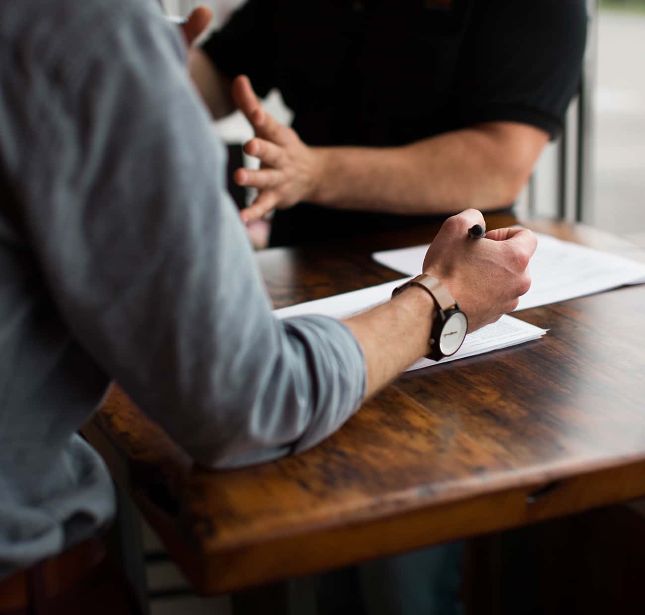 Two people working through documents at a wooden table