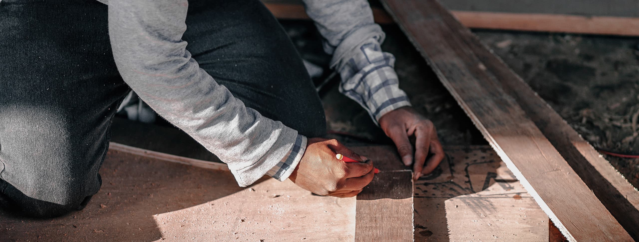 A craftsman measuring timber on a workbench